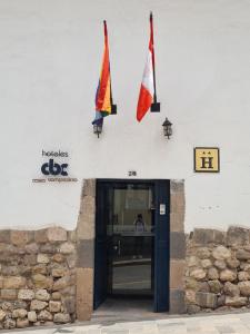 库斯科卡萨坎佩斯纳酒店的建筑物一侧的两面旗帜