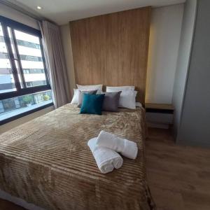 库里提巴Apartamento - Batel/Água Verde - Shopping Curitiba的一间卧室配有一张大床和毛巾