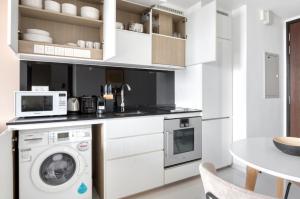 新加坡The Dapper Digs 2BR Apartment in Singapore的厨房配有洗衣机和微波炉。