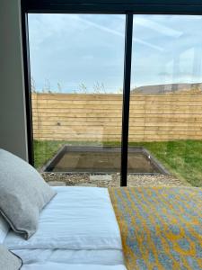雷克霍特Glass roof lodge with private hot tub的一间卧室设有一张床和一个大窗户
