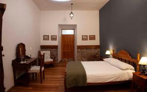 拉塔昆加拉谢内加庄园酒店的一间卧室配有一张床、一张桌子和一张书桌