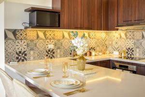 巴拿马城Modern luxury Studio with Rooftop + parking的厨房配有带盘子和玻璃杯的桌子