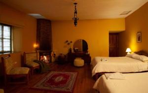 拉塔昆加拉谢内加庄园酒店的一间卧室设有两张床、镜子和壁炉