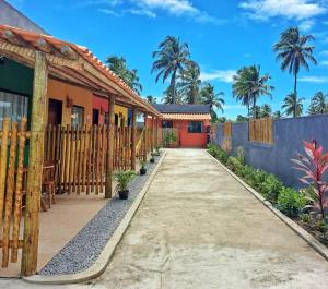 圣米格尔-杜斯米拉格里斯Villa Madu Milagres à 300 metros da praia的一个带栅栏和车道的房子