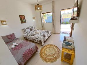 圣米格尔-杜斯米拉格里斯Villa Madu Milagres à 300 metros da praia的客厅配有床和沙发