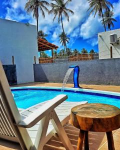 圣米格尔-杜斯米拉格里斯Villa Madu Milagres à 300 metros da praia的一个带椅子的游泳池和一个喷泉