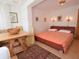 圣沃尔夫冈Landhaus Leitzinger OG1的一间卧室配有一张床和一张木桌
