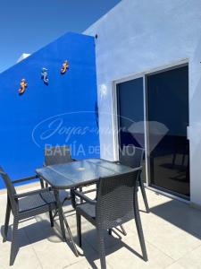 基诺湾Diamante Dos Joyas Del Mar Bahia de Kino的阳台设有一张桌子和椅子,拥有蓝色的墙壁