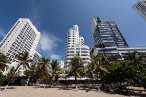 卡塔赫纳莱格特卡塔赫纳酒店的海滩前三座棕榈树高大的建筑