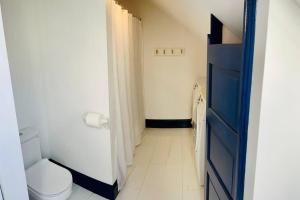 波特兰Host your group - West End Sea Captain Home的一间带卫生间和蓝色门的小浴室