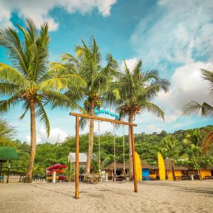 奥隆阿波Samba Bluewater Resort的棕榈树海滩上的秋千