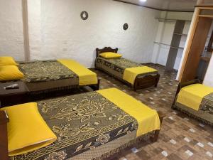 蒙特内哥罗Casa campestre Montenegro Quindio的一间设有三张黄色床单的房间