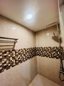奥隆阿波Samba Bluewater Resort的带淋浴的浴室(带瓷砖墙)