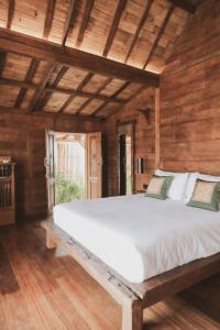吉利阿尔Kalyana Villa Gili Air的木墙客房内的一张大床