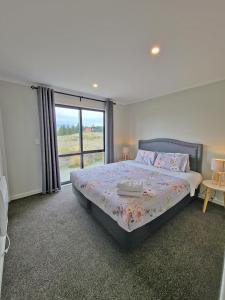 特卡波湖April Lodge的一间卧室设有一张床和一个大窗户