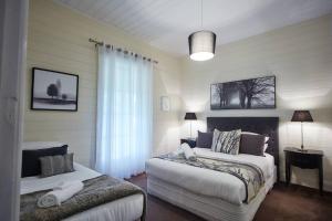 希尔斯维尔Inglenook Cottage Healesville的一间卧室设有两张床和窗户。