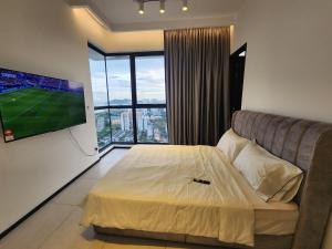 日落洞Urban Suites - Penang的一间卧室配有一张床、一台电视和一张沙发