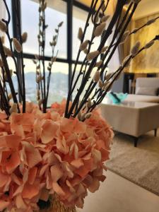 日落洞Urban Suites - Penang的客厅里装满粉红色花的花瓶