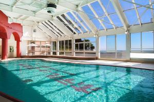 热海新赤尾酒店(Hotel New Akao)的一座带大型玻璃天花板的室内游泳池