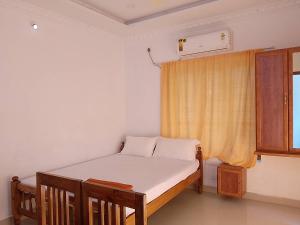 可瓦兰Somatheertham Panchakarma Resort的一间小卧室,配有床和窗户