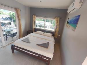 Ban NuaMoon Travel Phangan的一间卧室设有一张床、一个窗口和一张桌子