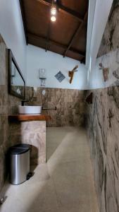 武吉拉旺Sam's Bungalows的浴室配有水槽和墙壁上的十字架
