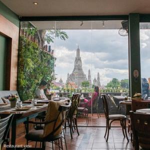 曼谷萨拉阿伦酒店的享有泰兰寺庙景致的餐厅