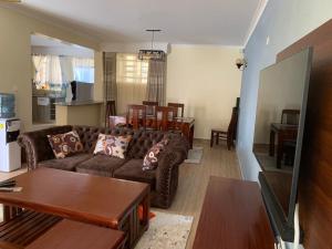 Kitengela 3 bedroom maisonette in Kitengela, Nairobi的客厅配有沙发和桌子