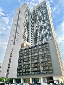 吉隆坡Chambers luxury suites KLCC的一座高大的建筑,前面有汽车停放