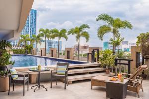 马尼拉维福瑞度假酒店的一个带游泳池和棕榈树的户外庭院