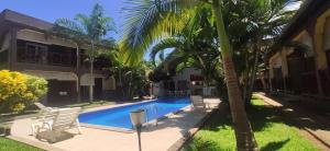 贝岛Résidence Kambana的棕榈树屋前的游泳池