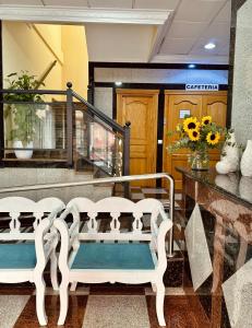 福恩吉罗拉雷耶索尔酒店的两个白色长椅,坐在大堂,花香