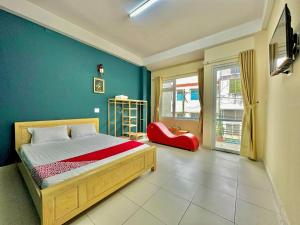 大叻OYO 1202 Ruby Motel Da Lat的一间卧室设有一张床和蓝色的墙壁