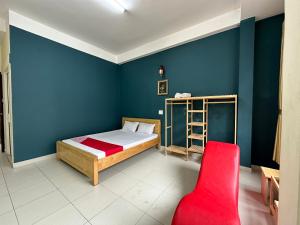 大叻OYO 1202 Ruby Motel Da Lat的一间卧室配有一张床和一张红色椅子