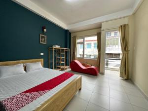 大叻OYO 1202 Ruby Motel Da Lat的一间卧室配有一张大床和一张红色椅子