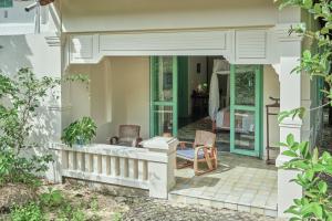 昆岛鲍罗神鹰精品温泉度假村的房屋设有门廊和两把椅子
