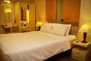 达卡华丽酒店的一张大白色的床,位于酒店客房内