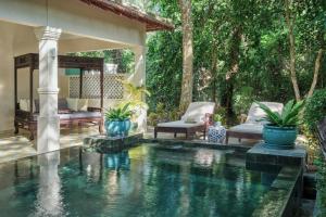 昆岛鲍罗神鹰精品温泉度假村的后院的游泳池,带椅子和房子