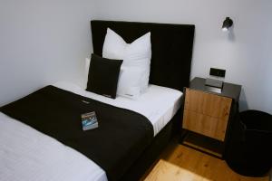 罗伊特林根KOCAK - Exklusives Apartment in Zentrumsnähe的一间卧室配有带白色床单和枕头的床。