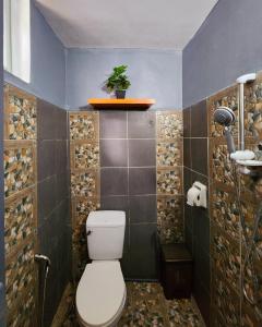 ItaytayUno Dus Tourist Inn的一间带卫生间和瓷砖墙的浴室