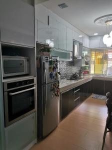 峇冬加里Iwan Ila Homestay的厨房配有不锈钢冰箱和微波炉。