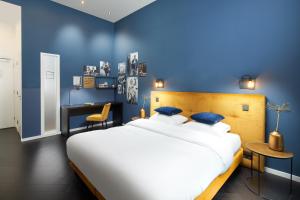 乌得勒支Court Hotel Utrecht City Centre的蓝色卧室配有一张大床和一张书桌