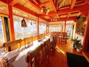 白马村Hakuba Pension & Log Hotel Meteor的大型用餐室配有长桌和椅子