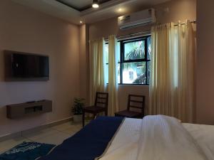 PinangodeIvyArk Residency的一间卧室设有一张床、一个窗口和一台电视。