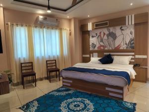 PinangodeIvyArk Residency的一间卧室配有一张大床和蓝色地毯。