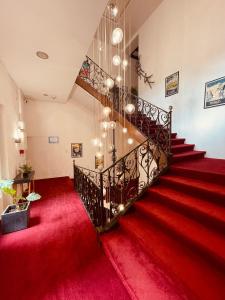 佩皮尼昂小屋酒店的铺有红地毯的楼梯和吊灯