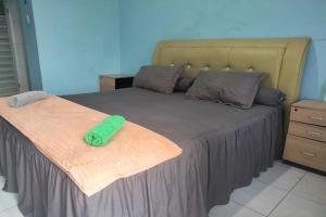 BinjaiOYO 93071 Home Stay Kembar Syariah的一间卧室配有一张带绿毛巾的床