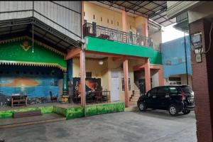 BinjaiOYO 93071 Home Stay Kembar Syariah的停在大楼前停车场的汽车