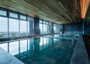 头城凯渡广场温泉酒店的一座带窗户的建筑中的游泳池