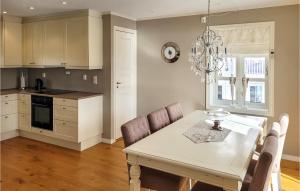 4 Bedroom Awesome Home In Strandvik的厨房配有桌椅和吊灯。